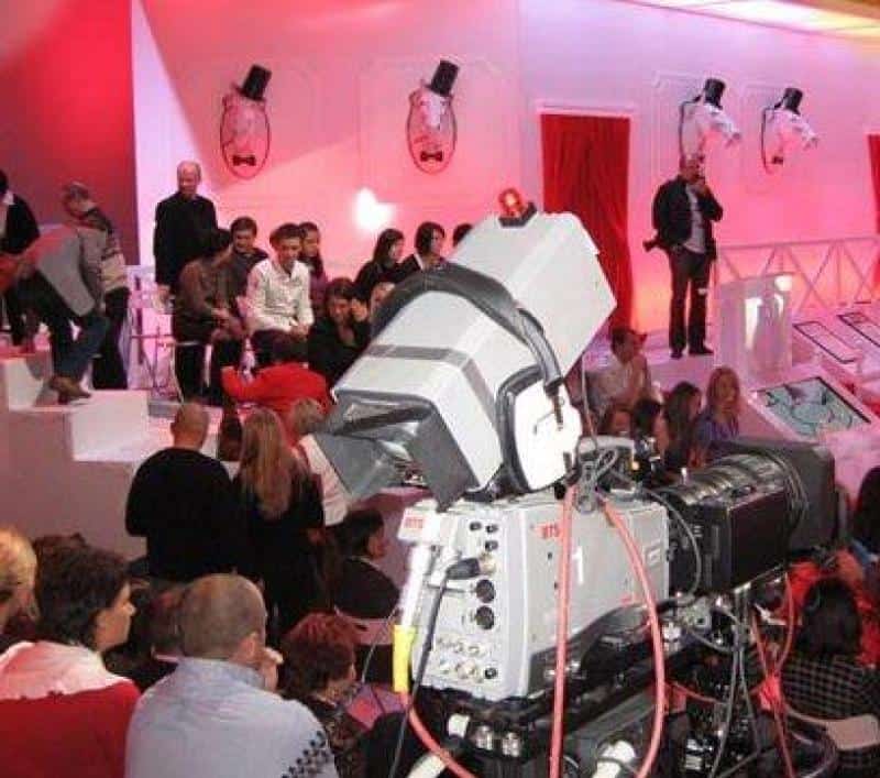 TVP2 - Elementy scenografii 3 Nagranie telewizyjne w studio z widownią i dużą kamerą na pierwszym planie. Dekoracje w czerwono-białej kolorystyce.