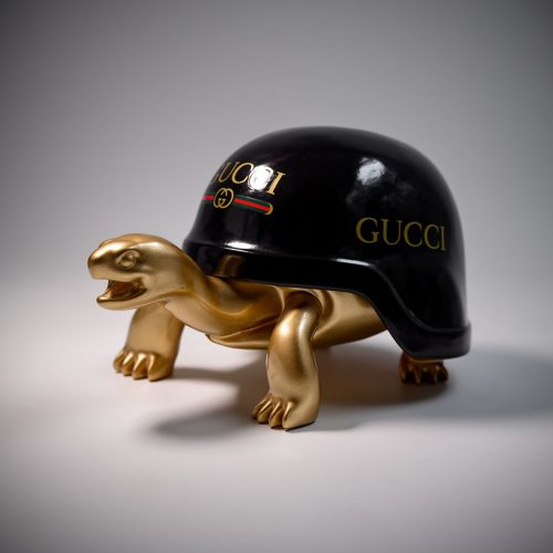 figura żółwia z czarną skorupą z laminatu z napisem Gucci i złotym, realistycznym korpusem z włókna szklanego