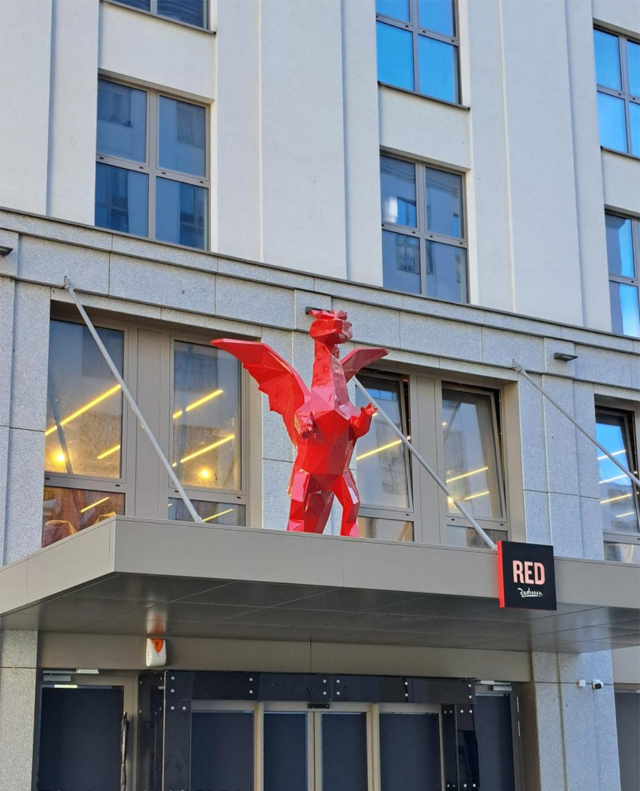 Smoki Low Poly w Hotelu Radisson 9 Czerwona rzeźba smoka nad wejściem do budynku Radisson RED.