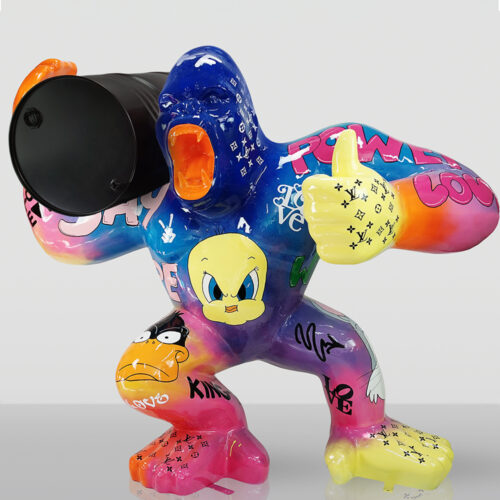 kolorowa rzeźba goryla w stylu pop-art trzymającego czarną beczkę, pomalowana z motywami kreskówek i różnymi napisami, w pozycji z otwartą paszczą i gestem kciuka w górę